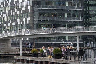 Cyclists on the Cykelslangen cycle and pedestrian bridge, at the Fisketorvet shopping centre,