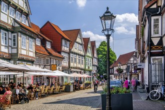 Schuhstrasse in the old town centre with typical half-timbered houses and street café, Celle,