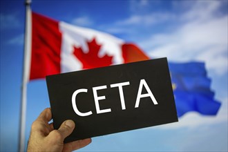 Sign reading CETA in front of the flags of Canada and the European Union. The abbreviation CETA