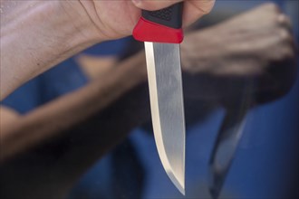 Symbolic image of a knife attack: close-up of a knife in a man's hand