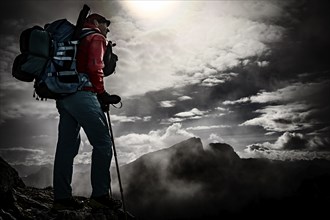 Mountaineer with luggage in the background Rätikon mountains with cloudy sky, Tschagguns, Rätikon,