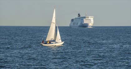 Sailboat and passenger ferry meet on the Baltic Sea outside Ystad, Sweden, Europe