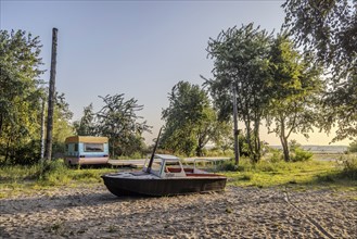 View of the natural beach with boat and old caravan. Peenemünde peninsula on the island of Usedom,