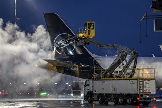 Winter at Frankfurt Main Airport, FRA, Lufthansa aircraft being de-iced by de-icing vehicles,