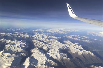 View from plane of snow covered mountain peaks in the Alps between France and Italy