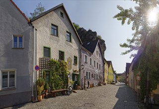 Sunlit Vils alley with historic buildings and plant decoration, Kallmünz, Upper Palatinate,