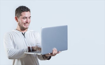 Excited guy holding and looking at an promotion on laptop screen. Portrait of happy young man