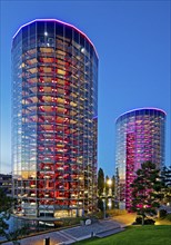 The illuminated car towers with new cars for delivery in the evening, Autostadt, Volkswagen AG,