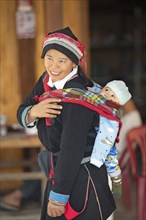 Vietnamese woman, 43 years old, in traditional traditional costume of the Dao minority, carrying