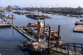 Hamburg harbour, Travehafen, working boats and barges, jetty, city skyline in the background,