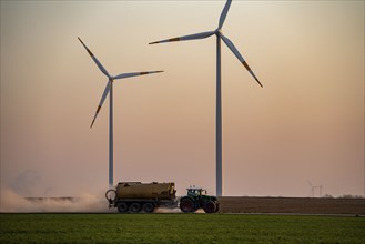 Tractor tilling a field in spring, spreading fermentation residue, residual slurry from biogas