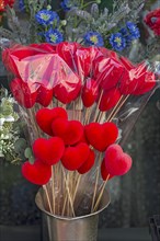 Red fabric hearts at a flower stand in front of the cemetery, Genoa, Italy, Europe