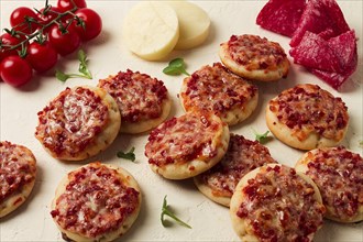 Mini pizzas, salami with mozzarella cheese, on a white table, top view, no people