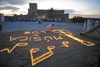 Castilian boy lighting candles, Pedraza Castle in the background, Conciertos de las Velas festival