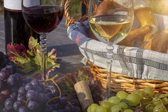 Symbolic image: Ripe grapes decorated with wine glasses on a wooden table