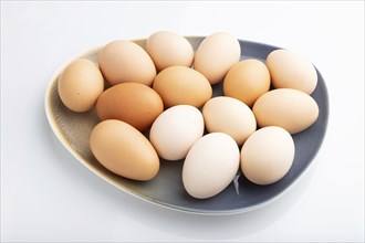 Pile of colored chicken eggs on plate isolated on white background. side view, close up