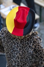 Woman with fur coat and hat in the German national colours black red gold, at a public viewing