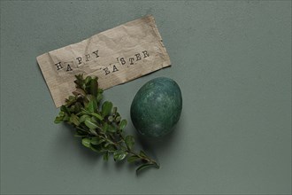 Easter card, green egg, boxwood branch, typewritten text, happy easter