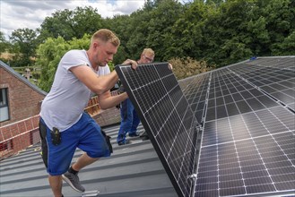 Installation of solar modules on the roof of a barn on a farm, over 210 photovoltaic modules are