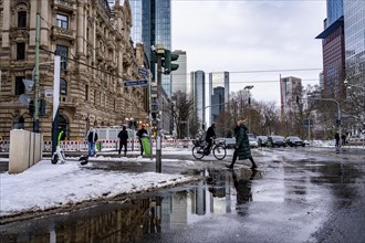 Winter in the city, Gallusanlage street, puddles, pools of water, melt water, pedestrians,