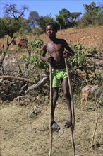 South Ethiopia, among the Benna people, boy on stilts, stilt walker, Ethiopia, Africa