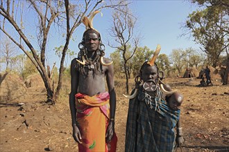 Southern Ethiopia, in Maco National Park, Mursi tribe, Mursi man, Mursi woman with baby, painted