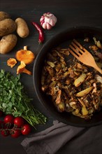 Fried chanterelles with mushrooms, in a clay pan, close-up, top view, selective focus