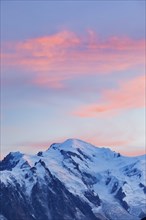 Red-coloured clouds over the summit of Mont Blanc with Aiguille du Midi in the foreground, Savoie,