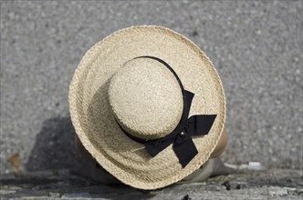 Woman with Straw Hat Leaning on the Wall