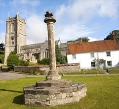 Church of St Michael and butter cross on the village green in Aldbourne, Wiltshire, England, United