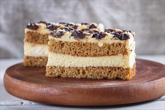 A piece of cake with milk and butter cream on a wooden kitchen board, close up, selective focus,