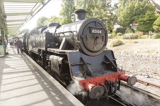 BR Standard Class 4 80104 steam locomotive train engine at platform of railway station, Swanage,