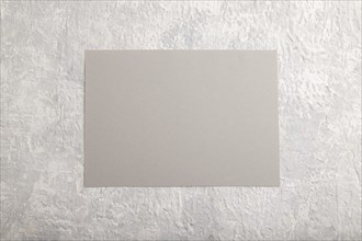 Gray paper business card, mockup on gray concrete background. Blank, flat lay, top view, still