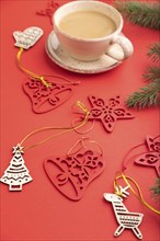 Christmas or New Year composition. Decorations, fir and spruce branches, cup of coffee, on a red