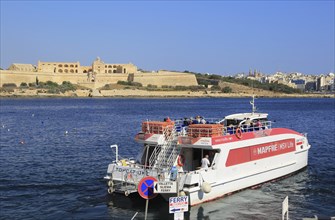 Mapfre Topcat ferry boat crossing harbour from Valletta to Sliema, Malta passing Fort Manoel