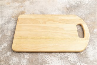 Empty rectangular wooden cutting board on brown concrete background. Side view, close up