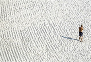 A young man talks on the phone on the beach in Sellin, 13/09/2016