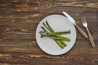 Overhead view of roasted asparagus with garlic, salt and pepper on a plate