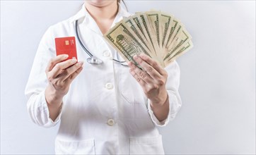 Female doctor hands holding credit card and money isolated. Unrecognizable doctor holding money and