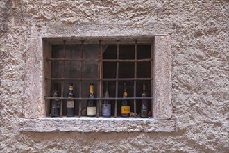 Barred window with empty champagne and wine bottles, Malcesine, Lake Garda, Province of Verona,