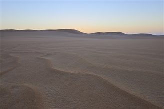 Vast desert landscape at sunset with gentle sand dunes and minimalist atmosphere, Matruh, Great