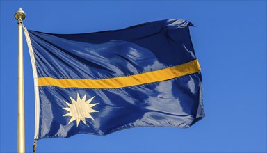 The flag of Nauru, an island nation in the Pacific Ocean, flutters in the wind, isolated against a