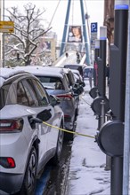 Winter in the city, electric cars charging at charging stations in the city centre of Frankfurt,