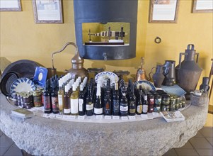 Antique display of products and bottles on a stone table in front of a yellow wall, products from