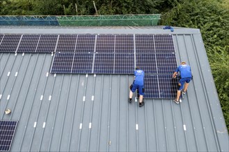 Installation of solar modules on the roof of a barn on a farm, over 240 photovoltaic modules are