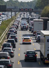 Emergency ambulance with flashing blue lights and siren working its way through a traffic jam on