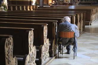 Old grey-haired man as the only churchgoer, interior of the Cistercian Abbey Church Fürstenfeld in