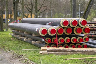 Pipe for district heating connections lying on a construction site on a stockpile, to be laid to