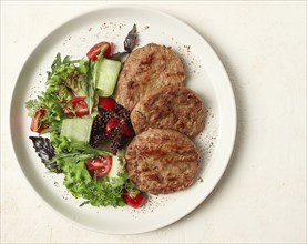 Fried cutlets, minced beef, with vegetable salad, top view, no people