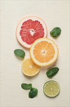 Food concept, wallpaper, sliced citrus fruits, top view, on a light table, with mint leaves, food